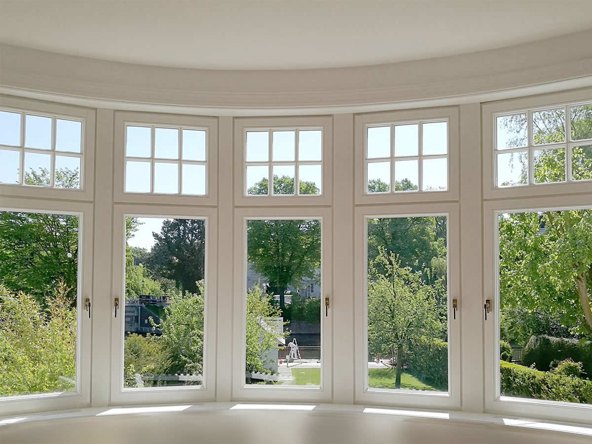 Gebogene Fensterfront mit Sprossen im Oberlicht