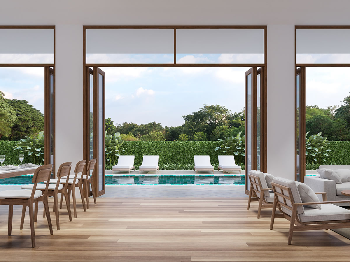 Geöffnete Faltschiebetüren einer Hotellobby mit Blick auf Poollandschaft